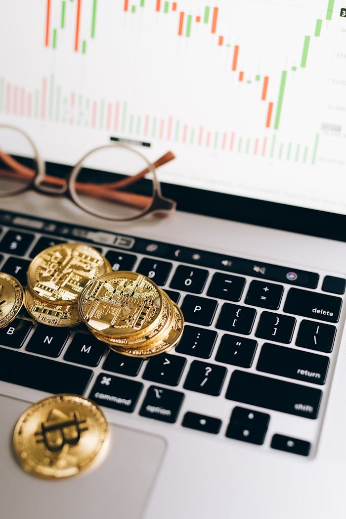 Bitcoins and a Laptop with Monitor Displaying a Chart